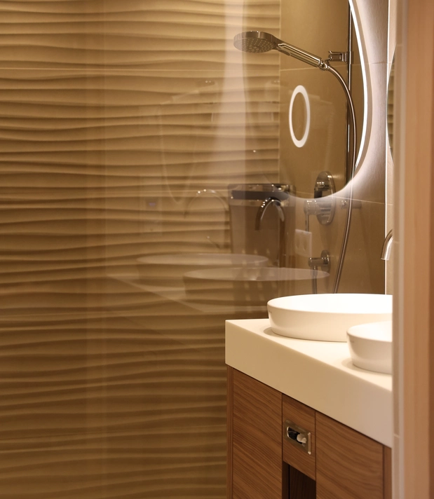 Badezimmer mit Doppelwaschbecken, beleuchtetem Spiegel und Dusche im Doppelzimmer Lifestyle Classic.