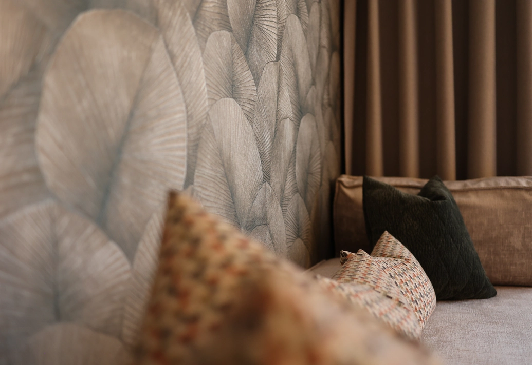 Wohnlicher Sitzbereich mit gemusterten Kissen und dekorativer Wandgestaltung im Doppelzimmer Lifestyle Classic.
