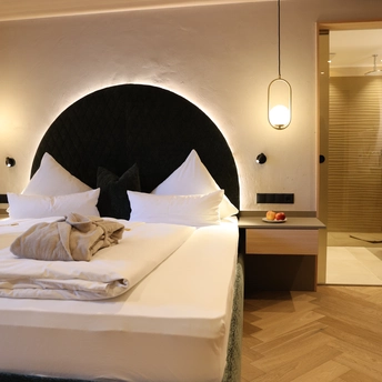 Modernes Doppelzimmer Lifestyle Classic mit gemütlichem Bett und offenem Badezimmer im Hotel Metzgerwirt in Laimach.
