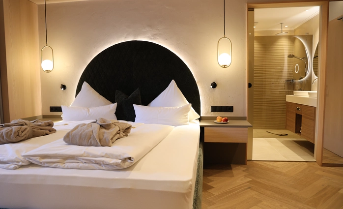 Modernes Doppelzimmer Lifestyle Classic mit gemütlichem Bett und offenem Badezimmer im Hotel Metzgerwirt in Laimach.